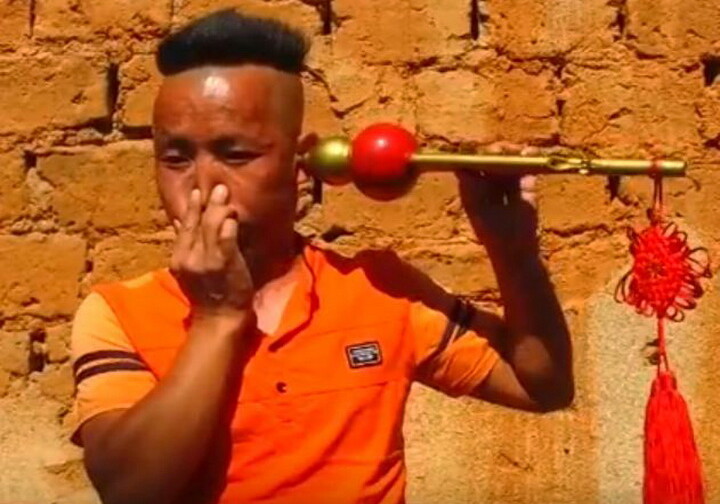 Житель Китая пьет ухом воду и играет им на дудочке (Видео)